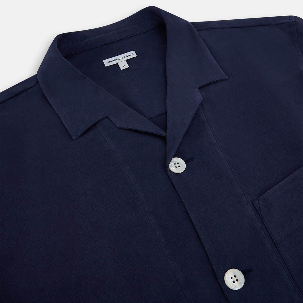 Turnbull & Asser Navy Silk Pyjama Set, laid flat on a white background, includes a long-sleeve button-up shirt with chest pocket and drawstring pants.