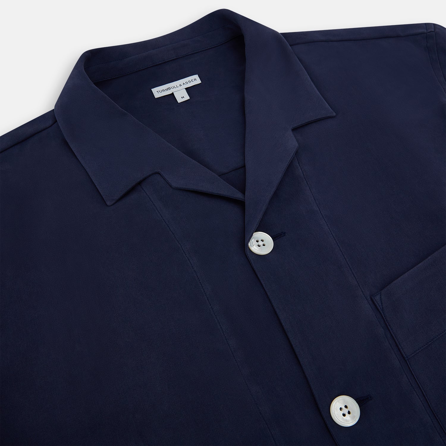 View 2 of product Turnbull & Asser Navy Silk Pyjama Set, laid flat on a white background, includes a long-sleeve button-up shirt with chest pocket and drawstring pants.