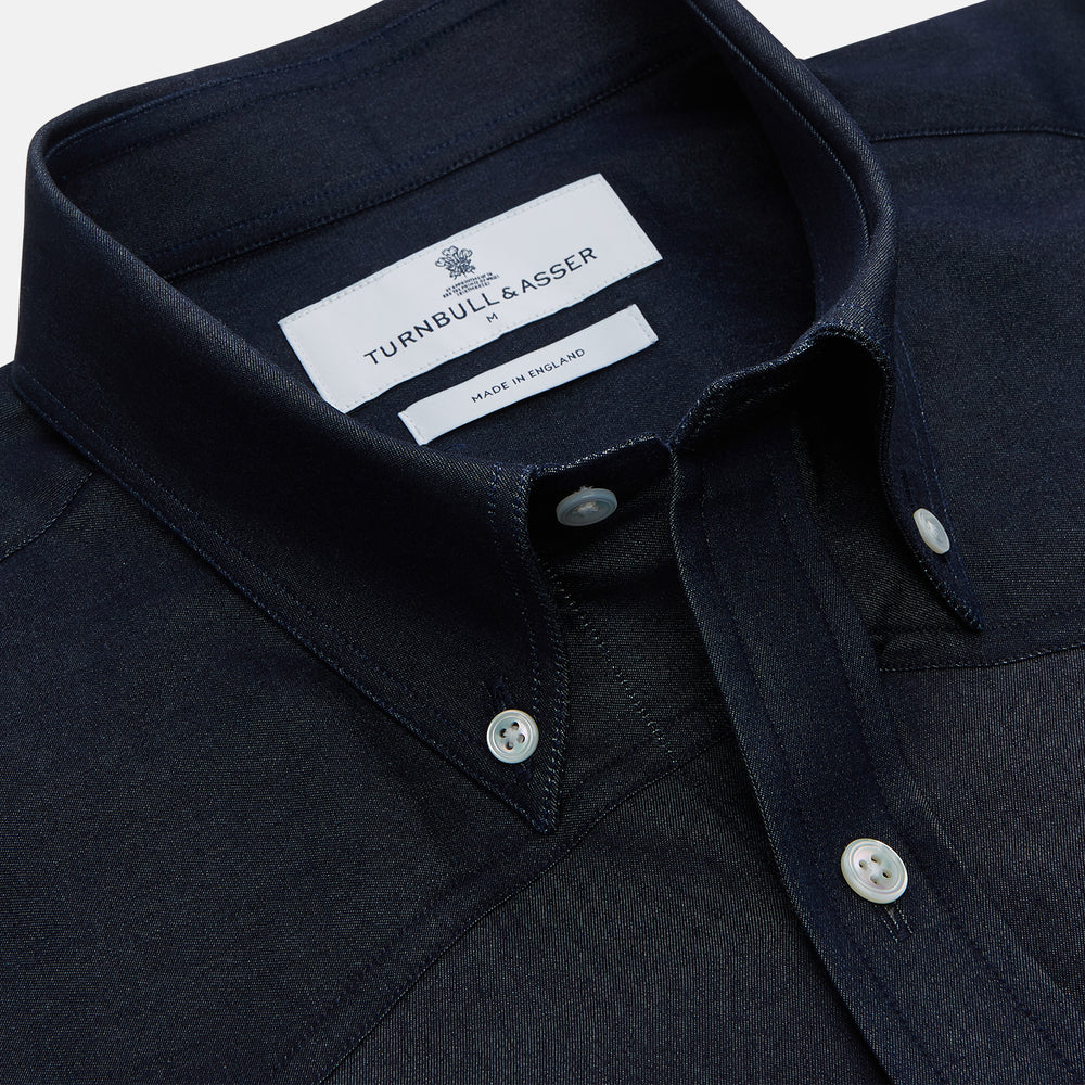The Turnbull & Asser Navy Weekend Fit Larkin Shirt features a Dorset collar, long sleeves with 3-button cuffs, two chest pockets, and white snaps, shown laid flat against a white background.