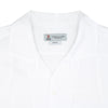 View 3 of product The White Lyocell Hampton Open Collar Shirt by Turnbull & Asser is neatly folded with visible label, notched collar, and buttons, displayed against a light grey background.