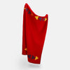 View 3 of product The Turnbull & Asser Red Applique Hand Stitched Lambswool Blanket features black-stitched edges and handsewn tie silk patches, including a yellow triangle and plaid triangle arranged to form a stylized fish.