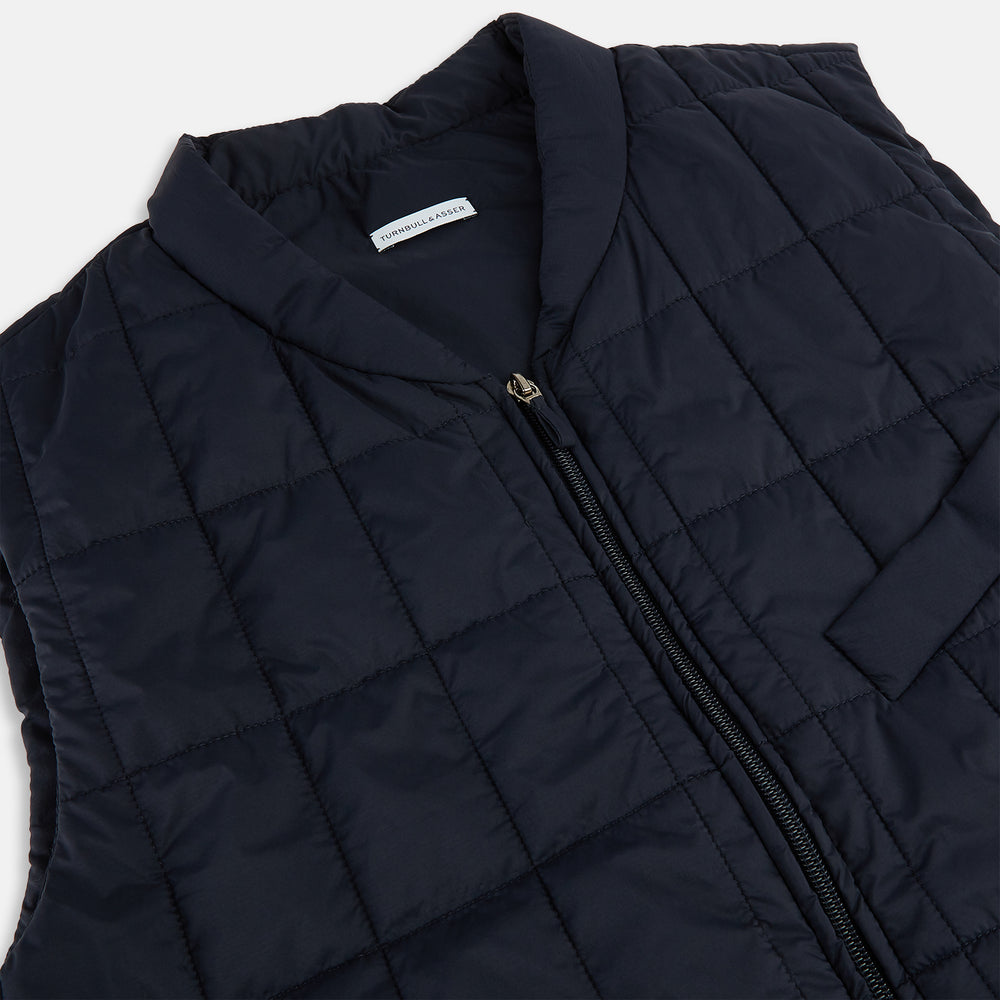 The Turnbull & Asser Navy Quilted Gilet is sleeveless and lightweight, with a front zipper, zippered side pockets, chest pocket, and rounded hem—ideal for versatile layering. Shown on a plain white background.