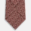 View 3 of product Turnbull & Asser's Burgundy Flower Patterned Silk Tie features small white and light red floral circles, shown rolled on a plain white background.