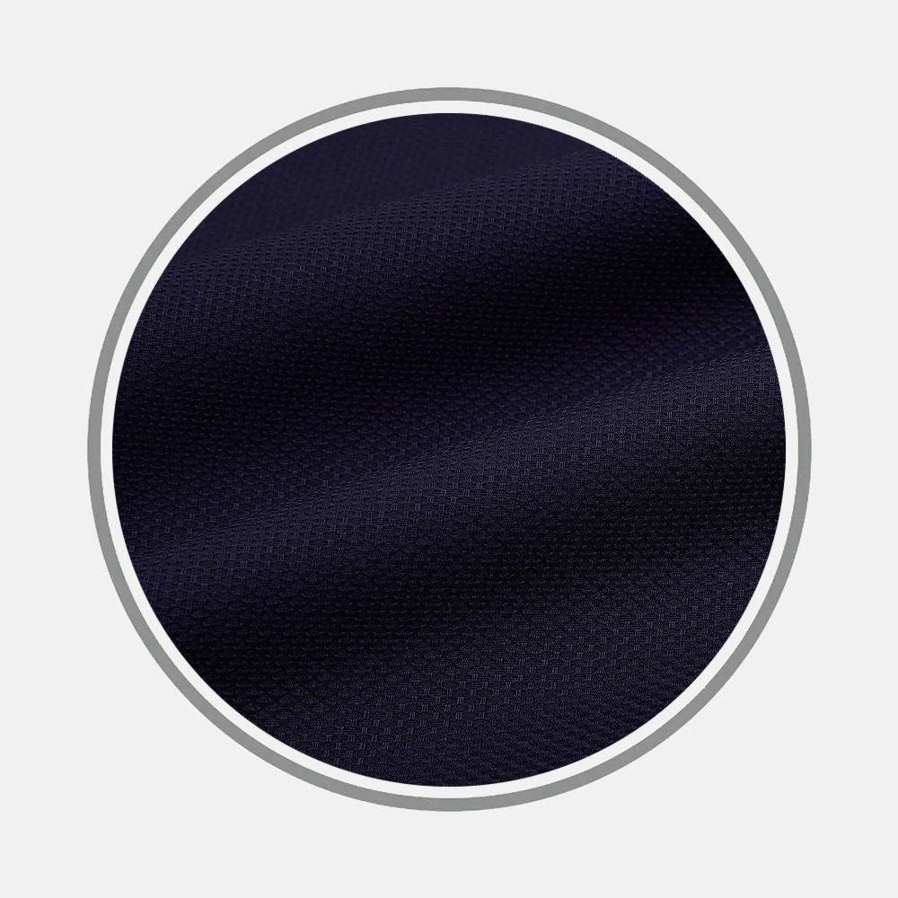 Close-up of Turnbull & Asser's Navy Textured Fabric inside a circular frame on a light gray background, highlighting the fabric’s fine weave and subtle diagonal folds.