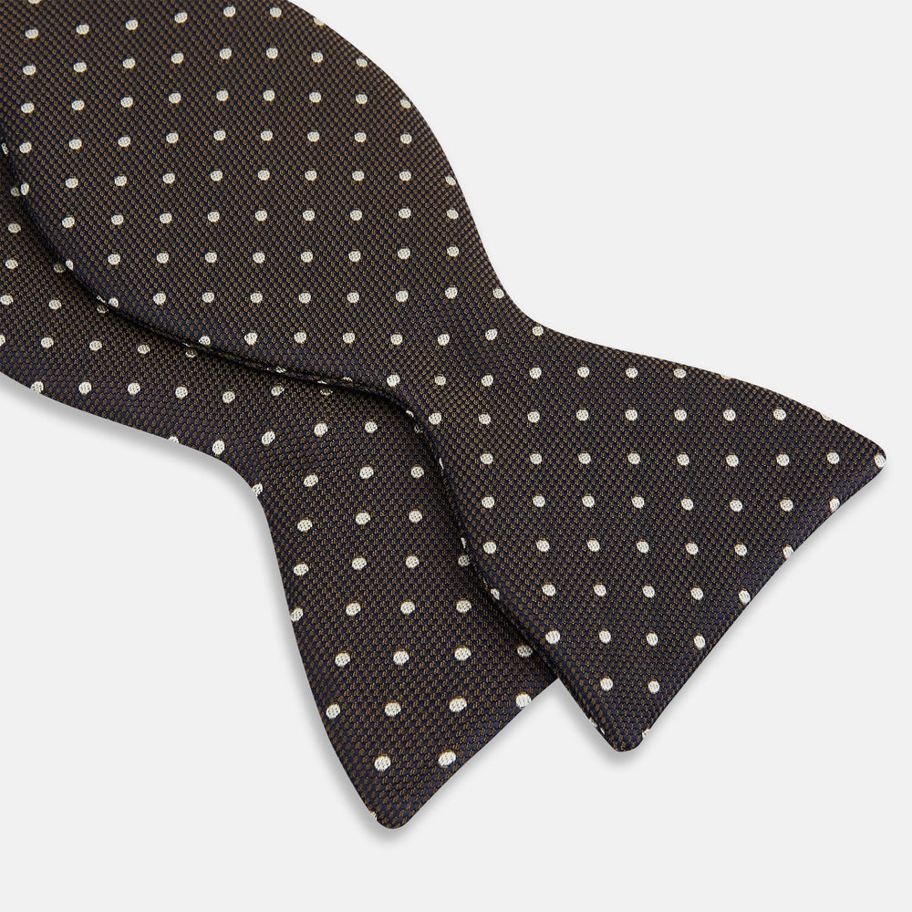 A stylish accessory, the White and Brown Micro Dot Silk Bow Tie by Turnbull & Asser features tiny brown dots on luxurious white silk, elegantly displayed against a plain white background.