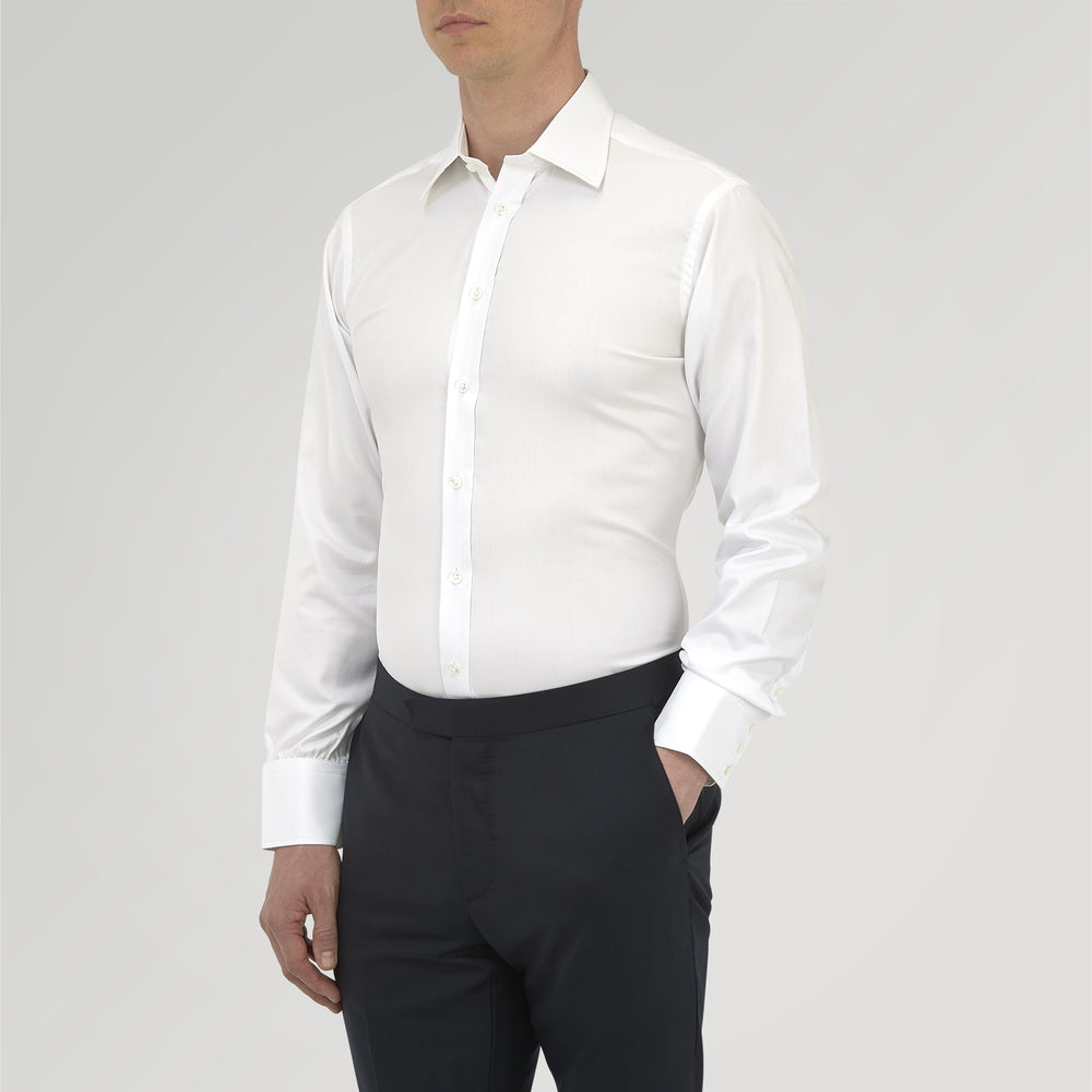 A neatly folded White Sea Island Quality Cotton Twill Shirt by Turnbull & Asser, featuring a T&A collar and 3-button cuffs, is displayed on a light grey background with a label visible inside the collar.