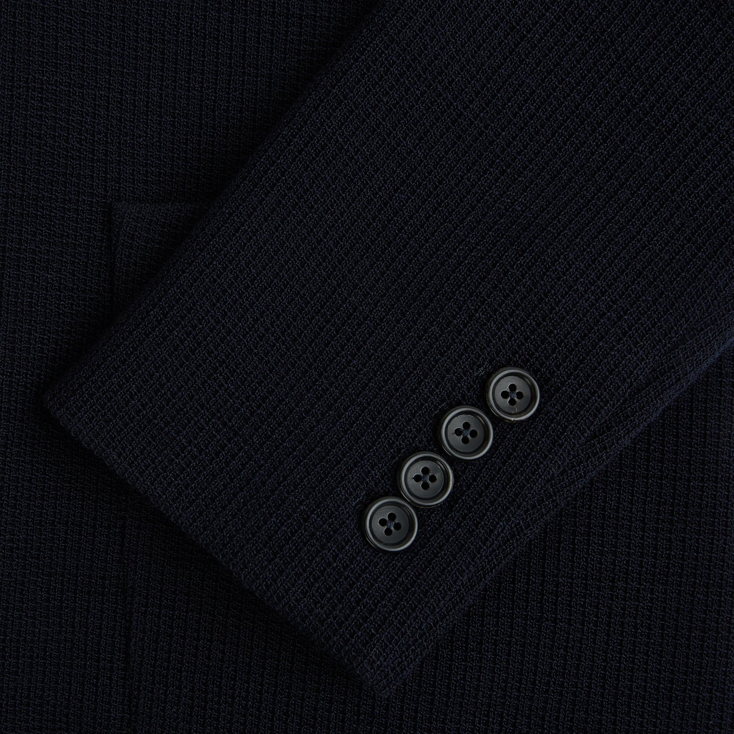 View 4 of product The Turnbull & Asser Navy Knitted Cambridge Blazer features a single-breasted design with three front patch pockets and two buttons, shown against a plain white background.