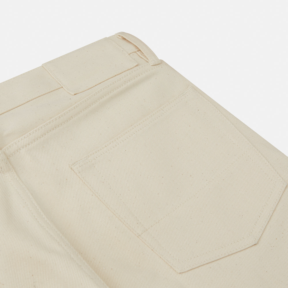 A pair of Turnbull & Asser Ecru Sanforized Denim Jeans with five pockets, button closure, and silver rivets, shown against a plain white background.