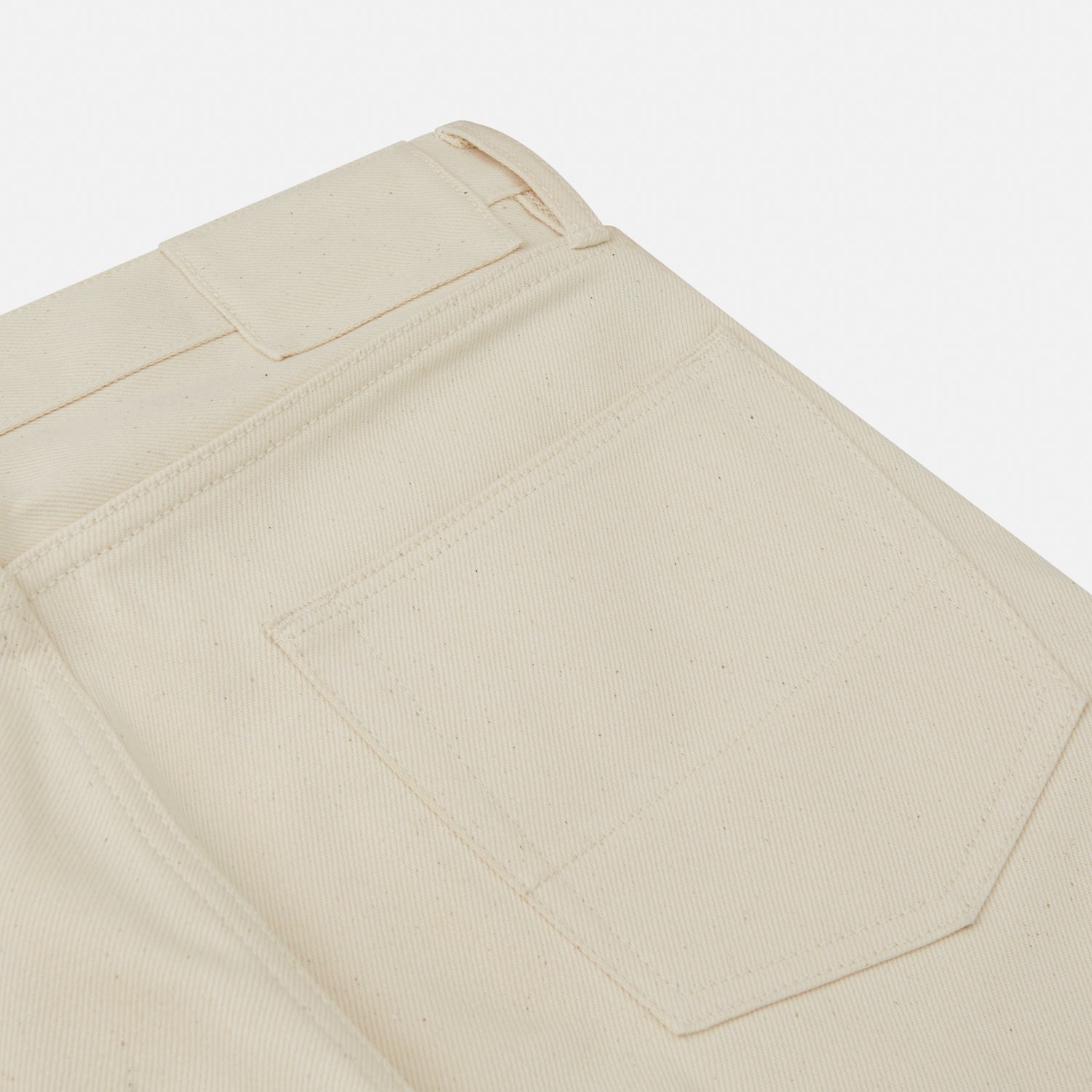 View 2 of product A pair of Turnbull & Asser Ecru Sanforized Denim Jeans with five pockets, button closure, and silver rivets, shown against a plain white background.