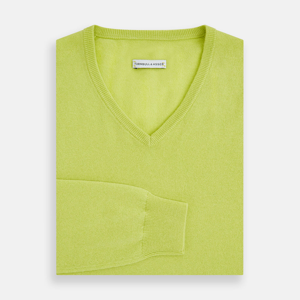 The Lemon Green Cashmere V-neck Jumper by Turnbull & Asser features ribbed cuffs and hem—an essential long sleeve knitwear piece, shown against a white background.