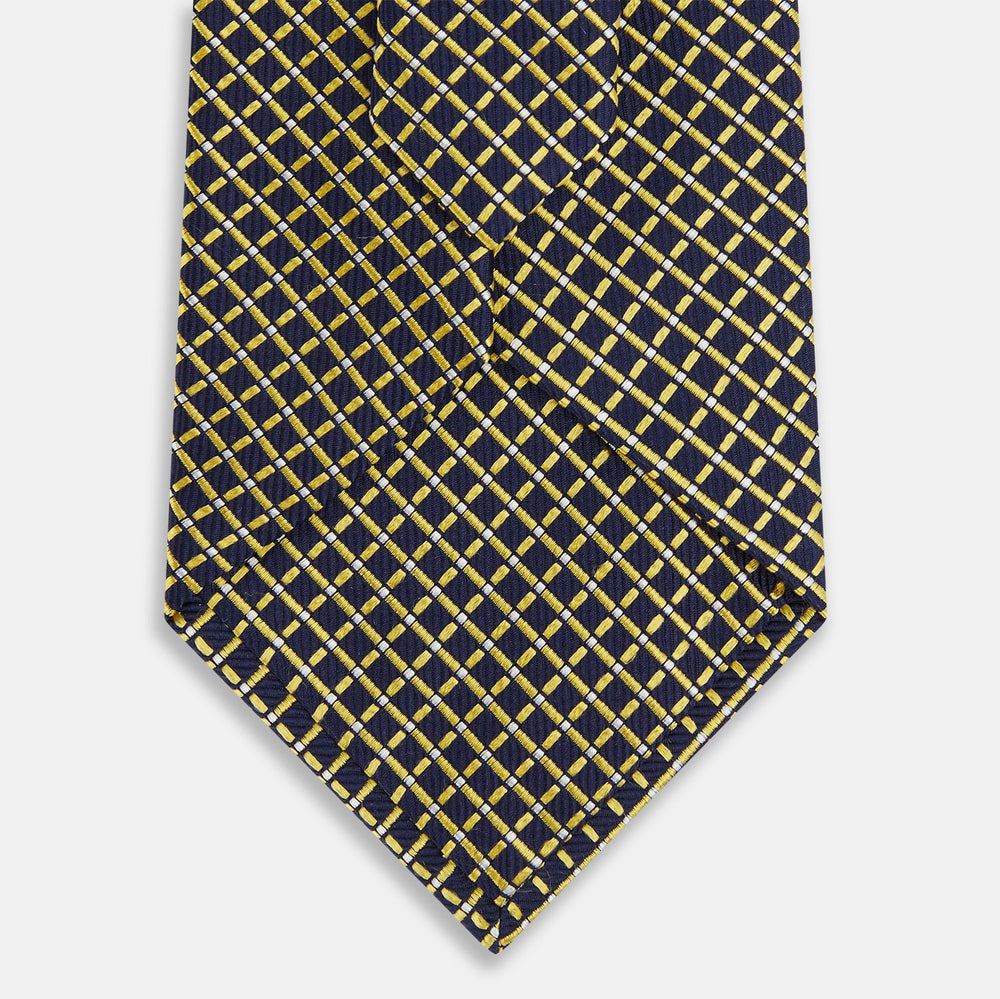 The Turnbull & Asser Yellow and Navy Diamond Silk Tie, with a refined yellow and light blue grid pattern, is elegantly rolled up on a plain white background.