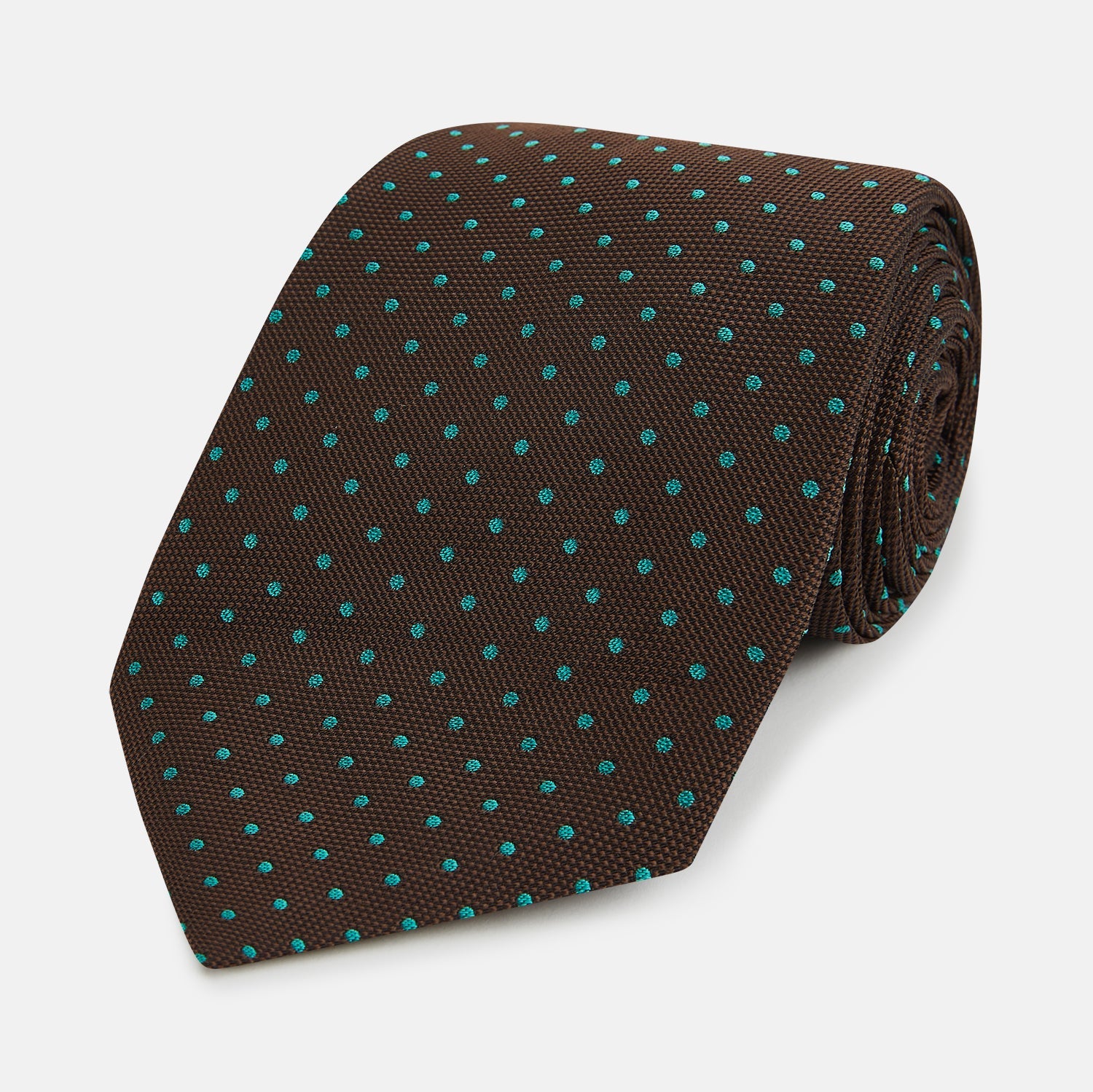 View 1 of product The Turnbull & Asser Green and Brown Micro Dot Silk Tie is shown rolled up, displaying its evenly spaced micro dot pattern against a plain white background.