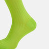 View 4 of product The Turnbull & Asser Lime Long Sock is a single bright green, knee-high sock with a ribbed texture, crafted from soft mercerised cotton, shown against a white background.