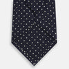 View 3 of product The Silver and Navy Micro Dot Silk Tie by Turnbull & Asser features a refined micro dot pattern, perfect for adding a classic accent to formal attire. Shown neatly rolled on a white background.
