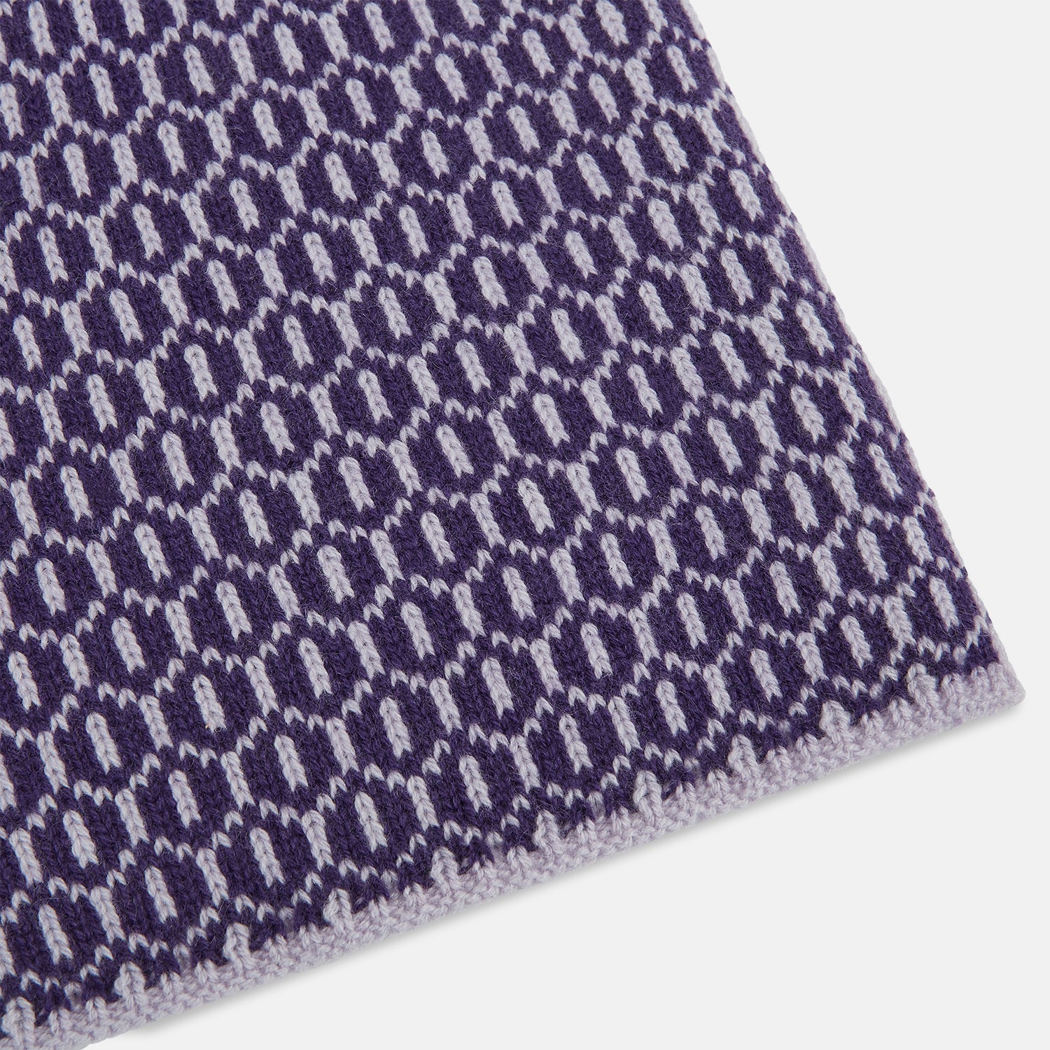 View 2 of product The Turnbull & Asser Purple and Lilac Hexagon Cashmere Knitted Scarf, featuring a white hexagon pattern, is neatly knotted and displayed on a plain background—a stylish accessory to elevate any outfit.