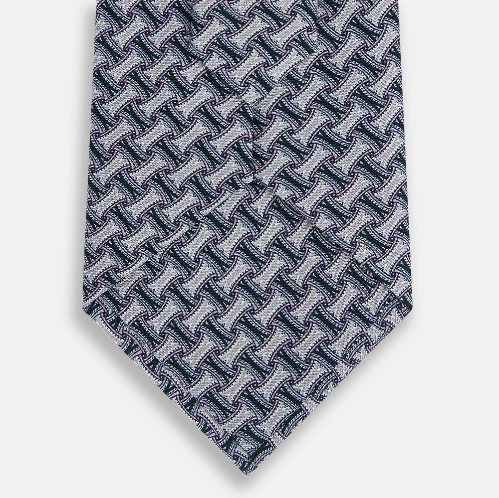 The Turnbull & Asser Navy and Pink Weave Patterned Silk Tie is shown elegantly rolled up on a white background.