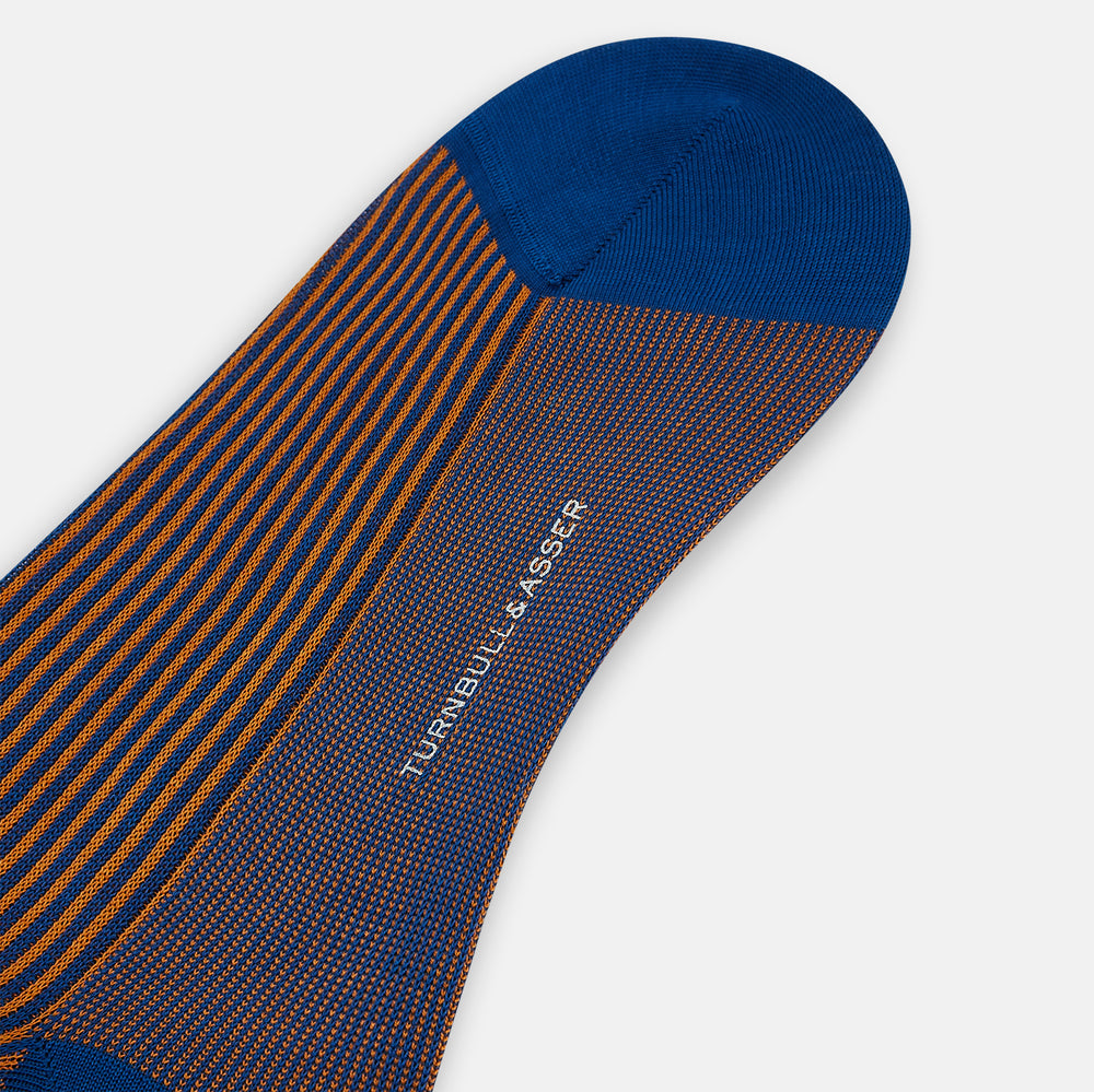 The Turnbull & Asser Royal Blue/Orange Thin Striped Long Sock is a knee-high, over-the-calf sock in mercerised Egyptian cotton, featuring vertical orange and dark blue stripes with blue cuff, heel, and toe. Displayed on a white background.