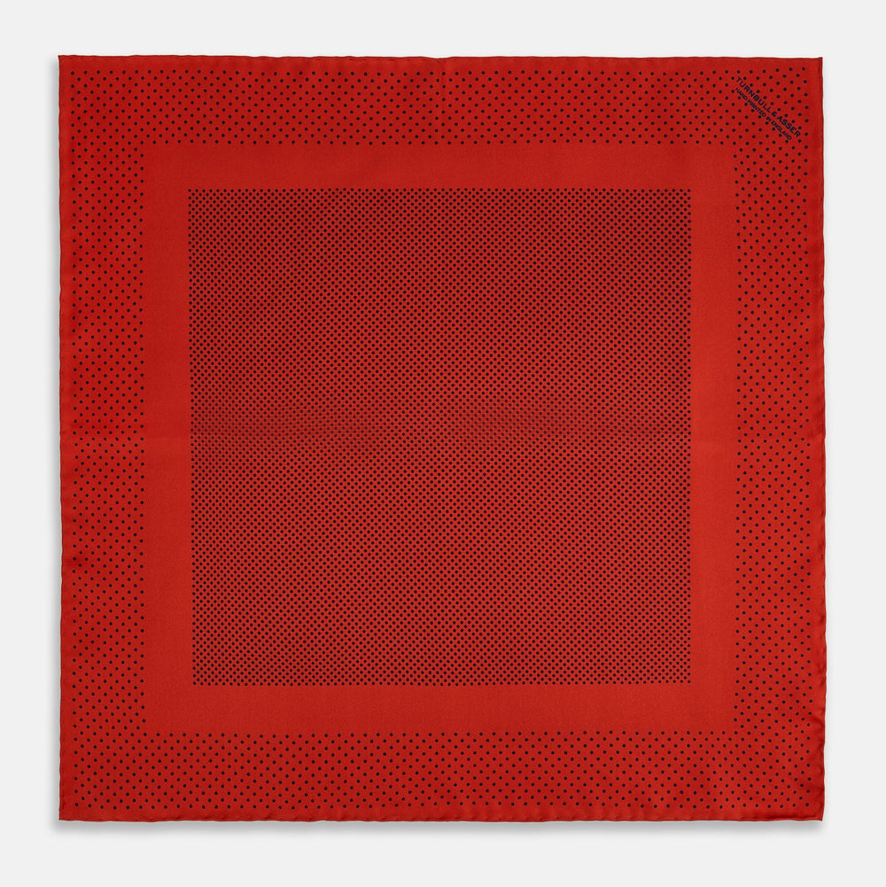 The Turnbull & Asser Red Dot Silk Pocket Square showcases small black dots on red silk, neatly folded to reveal both the front and part of the reverse side.