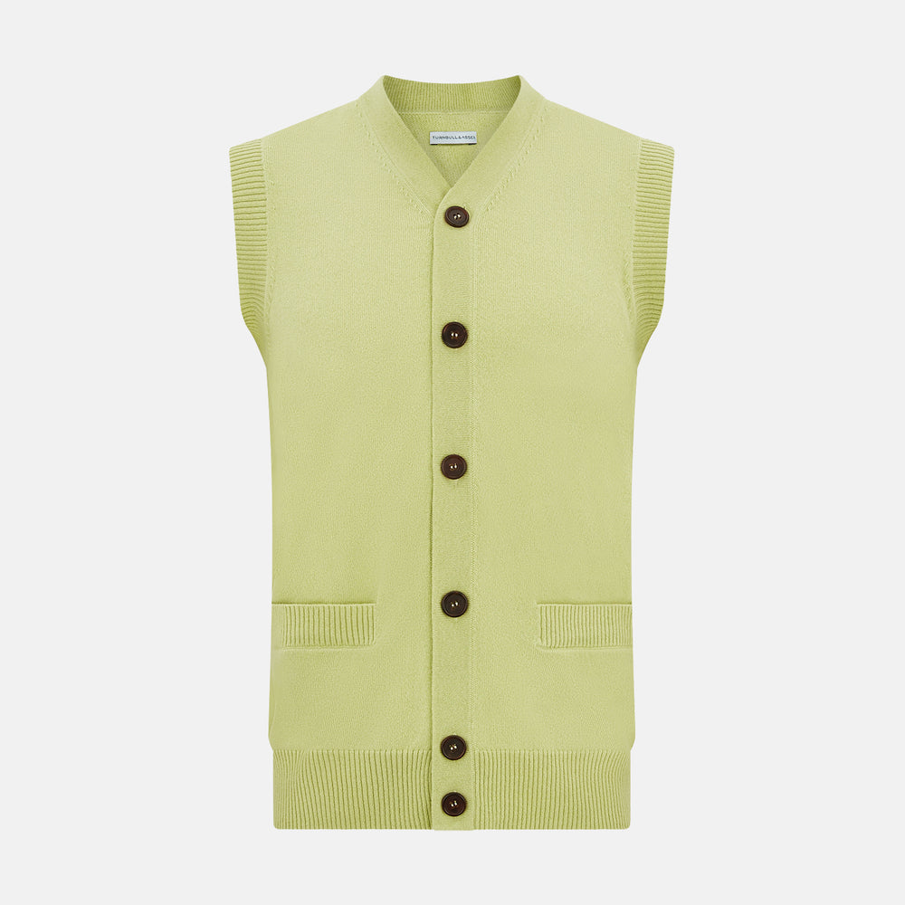 The Melon Green Sleeveless Cardigan by Turnbull & Asser features a ribbed collar, large brown buttons, and two front pockets—a stylish layering piece shown against a plain white background.