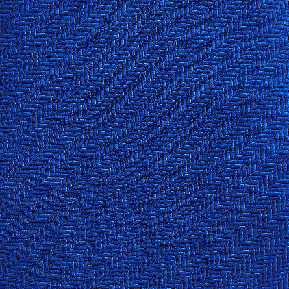 The Turnbull & Asser Plain Herringbone Cruise Tie in bright blue, shown rolled up on a white background, features a subtle chevron pattern—an essential finishing touch for your smart look.