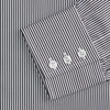 View 3 of product The Turnbull & Asser Black Candy Stripe Cotton Regular Fit Mayfair Shirt features long sleeves, a T&A collar, white buttons, and thin black stripes, displayed on a plain white background.