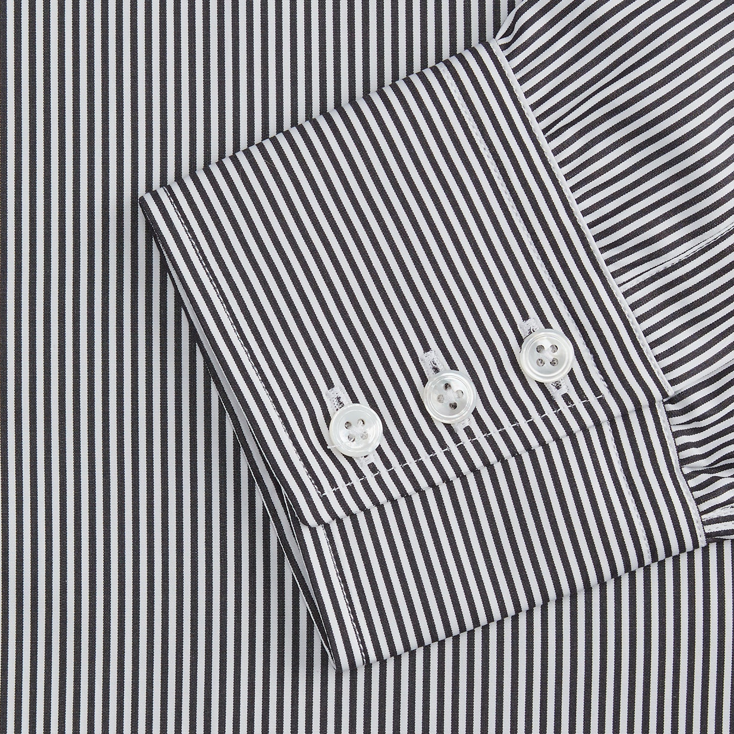 View 3 of product The Turnbull & Asser Black Candy Stripe Cotton Regular Fit Mayfair Shirt features long sleeves, a T&A collar, white buttons, and thin black stripes, displayed on a plain white background.