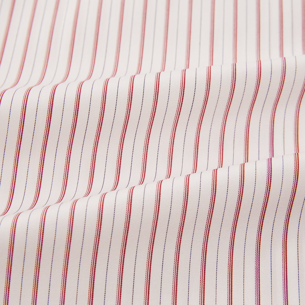 The Red Multi Ticking Stripe Mayfair Shirt by Turnbull & Asser features thin red and blue vertical stripes on white, a T&A collar, long sleeves, and button-up design.
