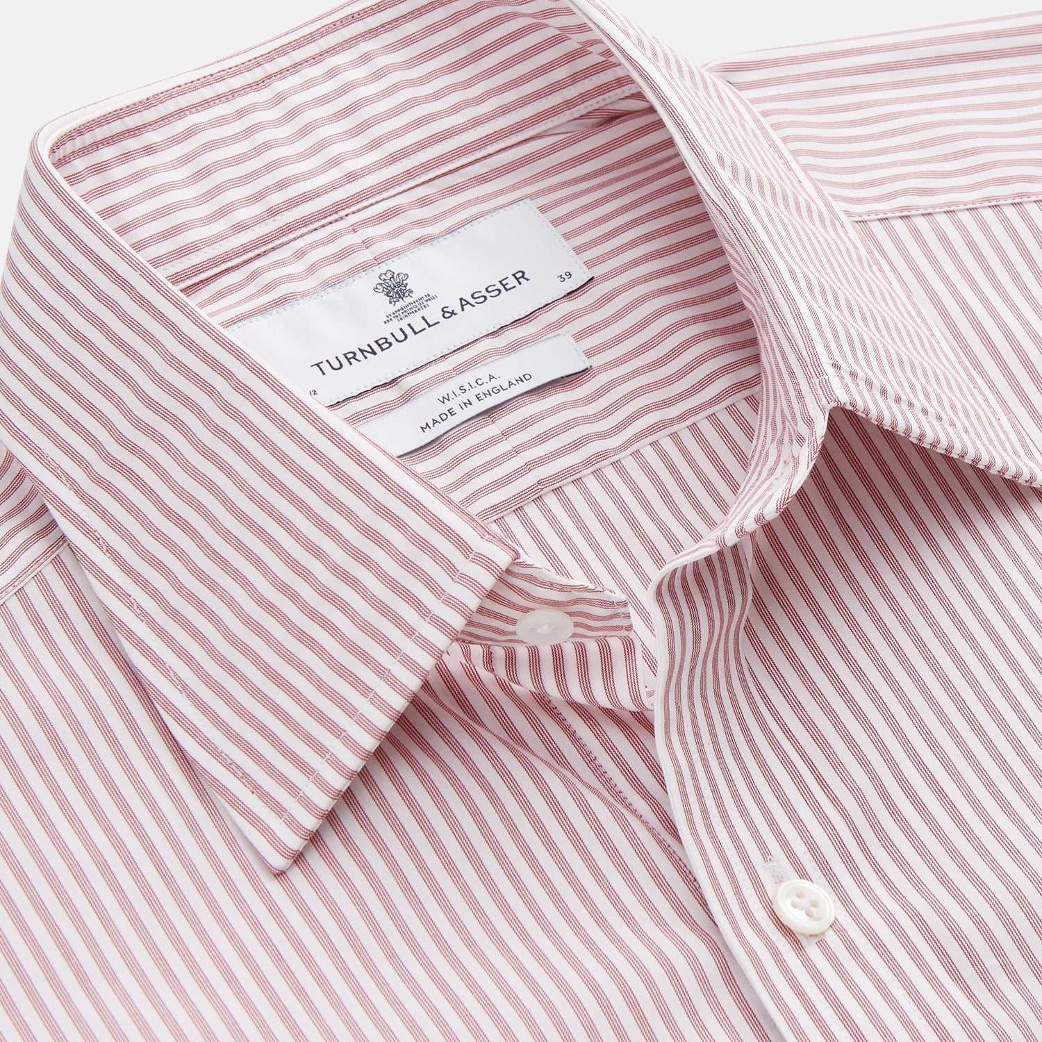 View 3 of product The Turnbull & Asser Burgundy Stripe West Indian Sea Island Cotton Regular Fit Mayfair Shirt features thin vertical red and white stripes, a classic collar, and long sleeves, shown on a plain white background.