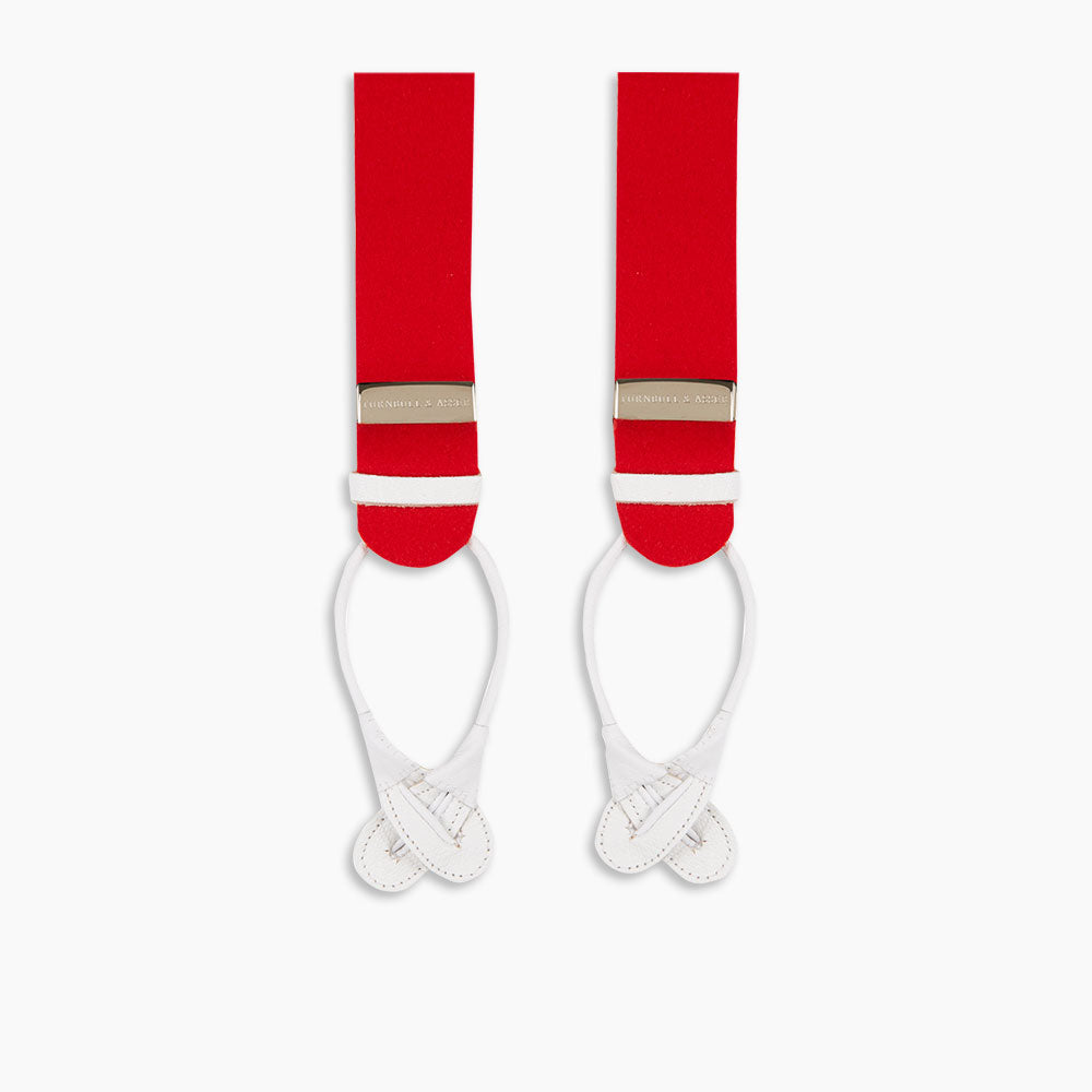 Turnbull & Asser’s Red Adjustable Felt Braces, crafted in England from traditional boxcloth, feature white leather loop ends and silver metal adjusters. The braces are laid flat on a white background.