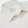 View 2 of product The Turnbull & Asser Cream Silk Tailored Fit Shirt is a long-sleeve button-up with a pointed collar and buttoned cuffs, displayed laid flat against a plain white background.