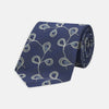 View 1 of product The Turnbull & Asser Navy Jacquard Silk Floral Tie features white and light blue abstract leaf designs, exemplifying fine British craftsmanship. Shown rolled up against a white background.