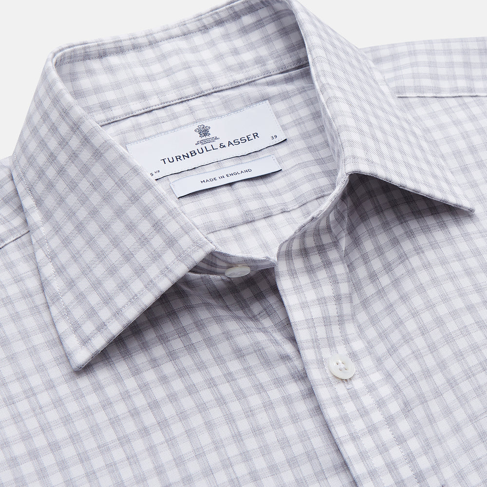 The Grey Check Cotton Melange Regular Fit Mayfair Shirt by Turnbull & Asser features a light gray and white small checkered pattern, a collar, and front buttons, shown against a white background.
