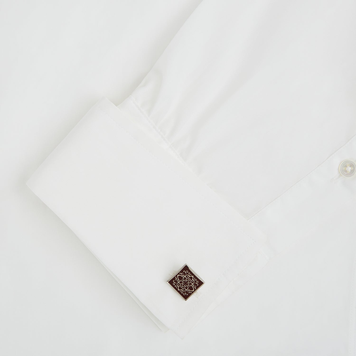 View 3 of product Turnbull & Asser Burgundy Floral Square Cufflinks feature a reddish-brown enamel face with an intricate white mandala pattern at the center, all set in elegant sterling silver.