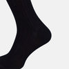 View 4 of product A single Midnight Thick Knit Mid-Length Sock by Turnbull & Asser, crafted from black mercerised Egyptian cotton, is shown in side profile against a plain white background with the toe pointing left.