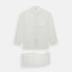 The Turnbull & Asser Cream Silk Pyjama Set, shown laid flat on a white background, features a long-sleeve button-up top with a chest pocket and matching pants with an elastic drawstring waist—ideal for comfortable loungewear.