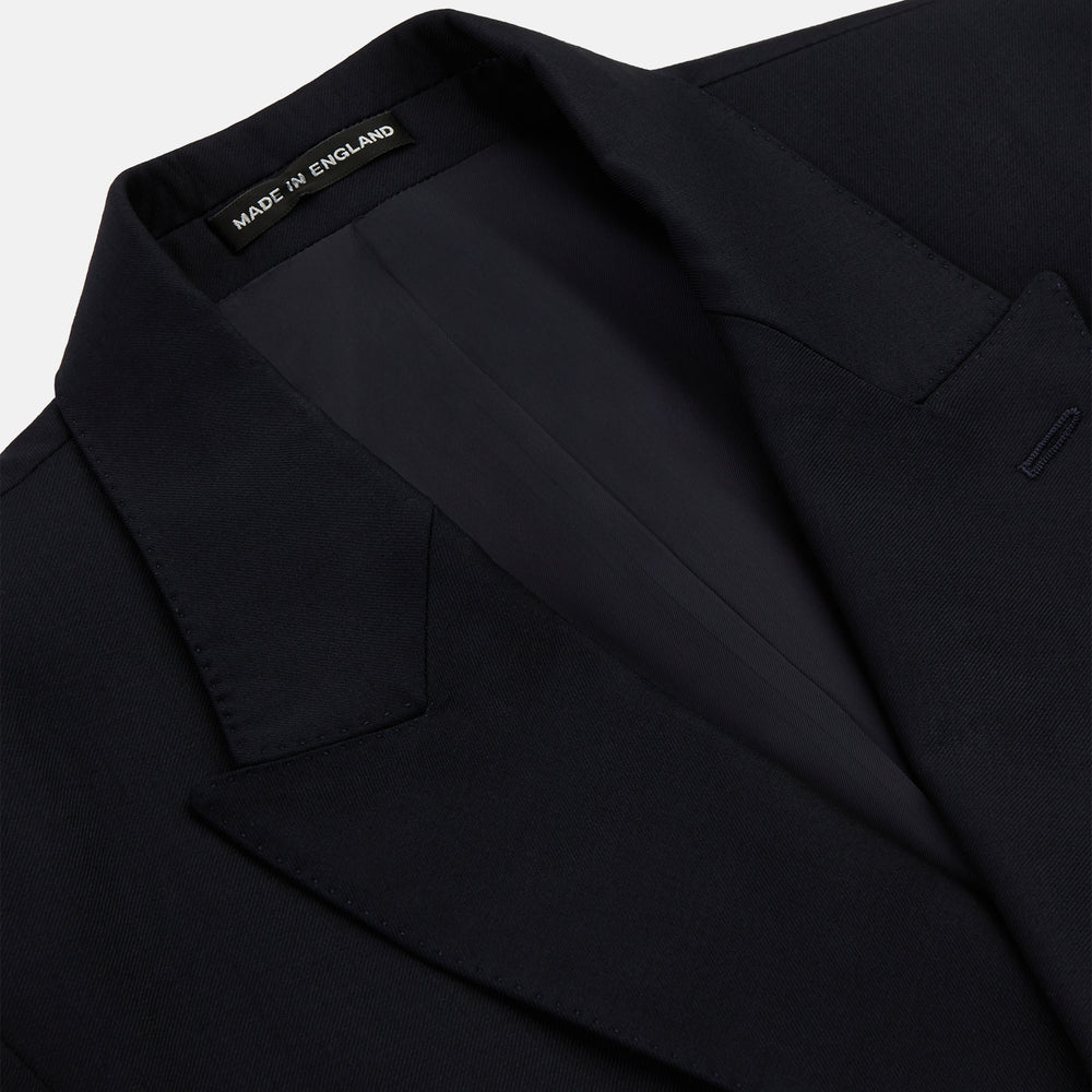 The Classic Navy Wool Blazer by Turnbull & Asser is a nautical double-breasted jacket with gold buttons, peaked lapels, three front pockets on one side, one on the other, and four gold buttons per cuff, shown against a white background.
