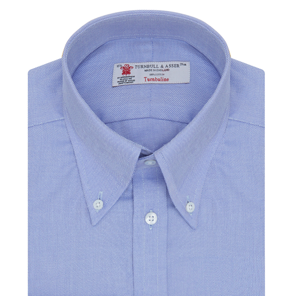 The Turnbull & Asser Blue Royal Oxford Cotton Shirt features a button-down collar, 3-button cuffs, and a visible brand label, shown neatly folded on a white background—ideal for pairing with a navy suit.