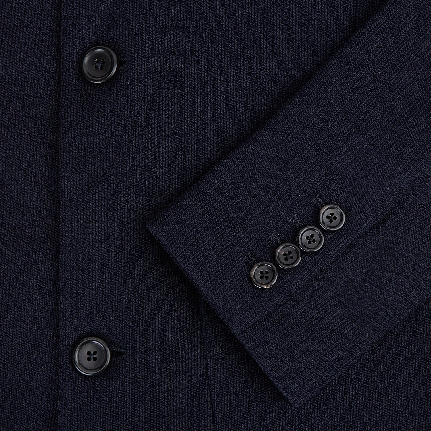 View 4 of product The Navy Knitted Oxford Blazer by Turnbull & Asser features notch lapels, two front buttons, a chest pocket, and two lower patch pockets, shown against a plain white background.