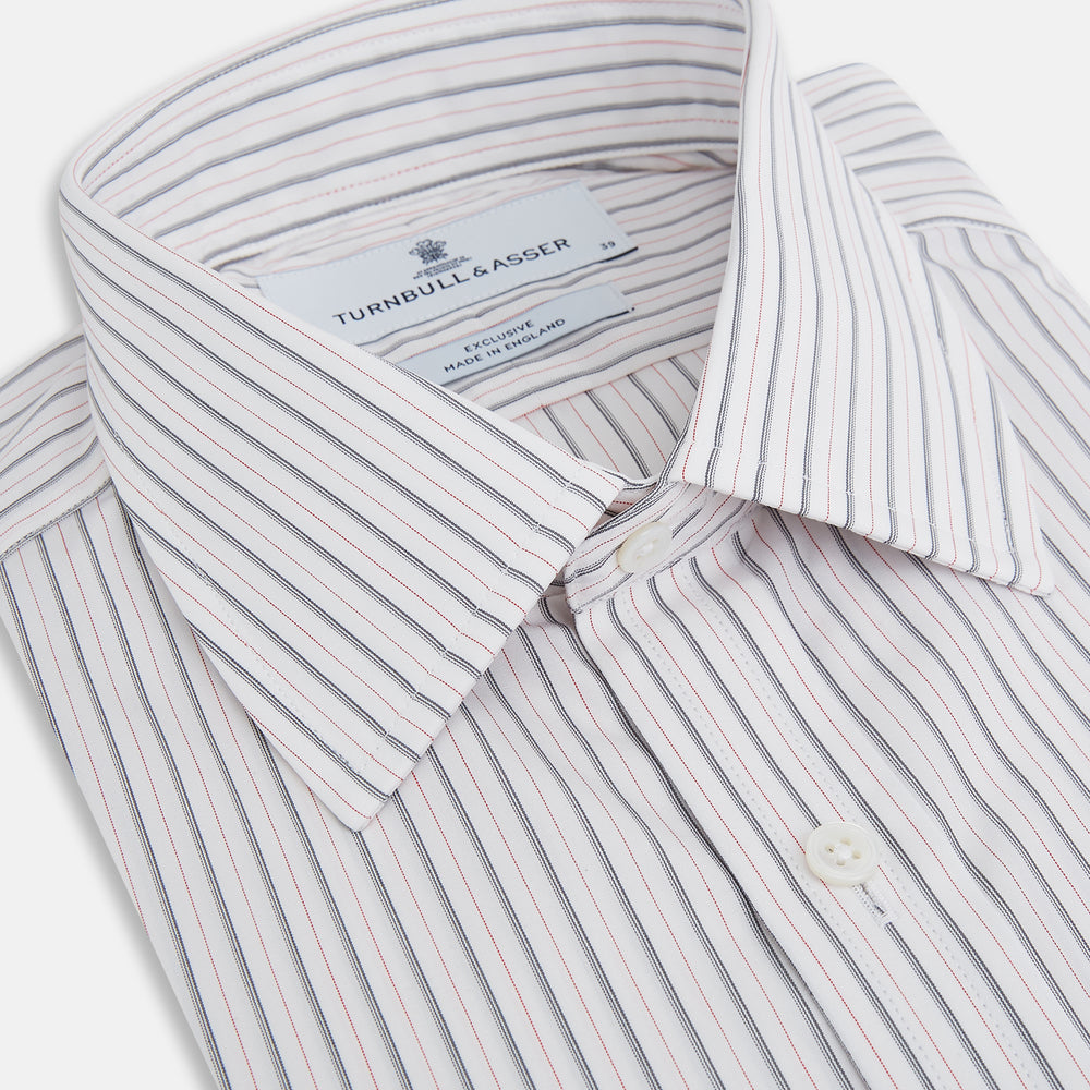 The Turnbull & Asser Midnight Blue and Red Ticking Stripe Mayfair Shirt features long sleeves, a pointed collar, buttoned cuffs, and fine Italian cotton—an essential men's wardrobe piece shown on a plain white background.