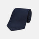 The Turnbull & Asser Navy Plain Woven Grenadine Silk Tie, an essential accessory, is rolled at one end and displayed on a plain white background.