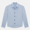 View 1 of product The Turnbull & Asser Pale Blue Hyde Overshirt is a long-sleeve, sanforised cotton button-up with a single chest pocket and dark buttons, shown on a plain white background.