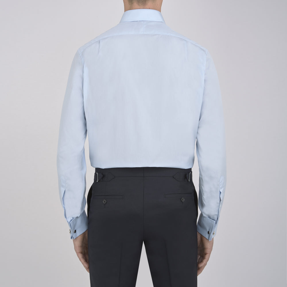 The Turnbull & Asser Light Blue Sea Island Quality Cotton Shirt features a T&A collar, double cuffs, white buttons, and a quality label inside the collar. Displayed on a plain white background.