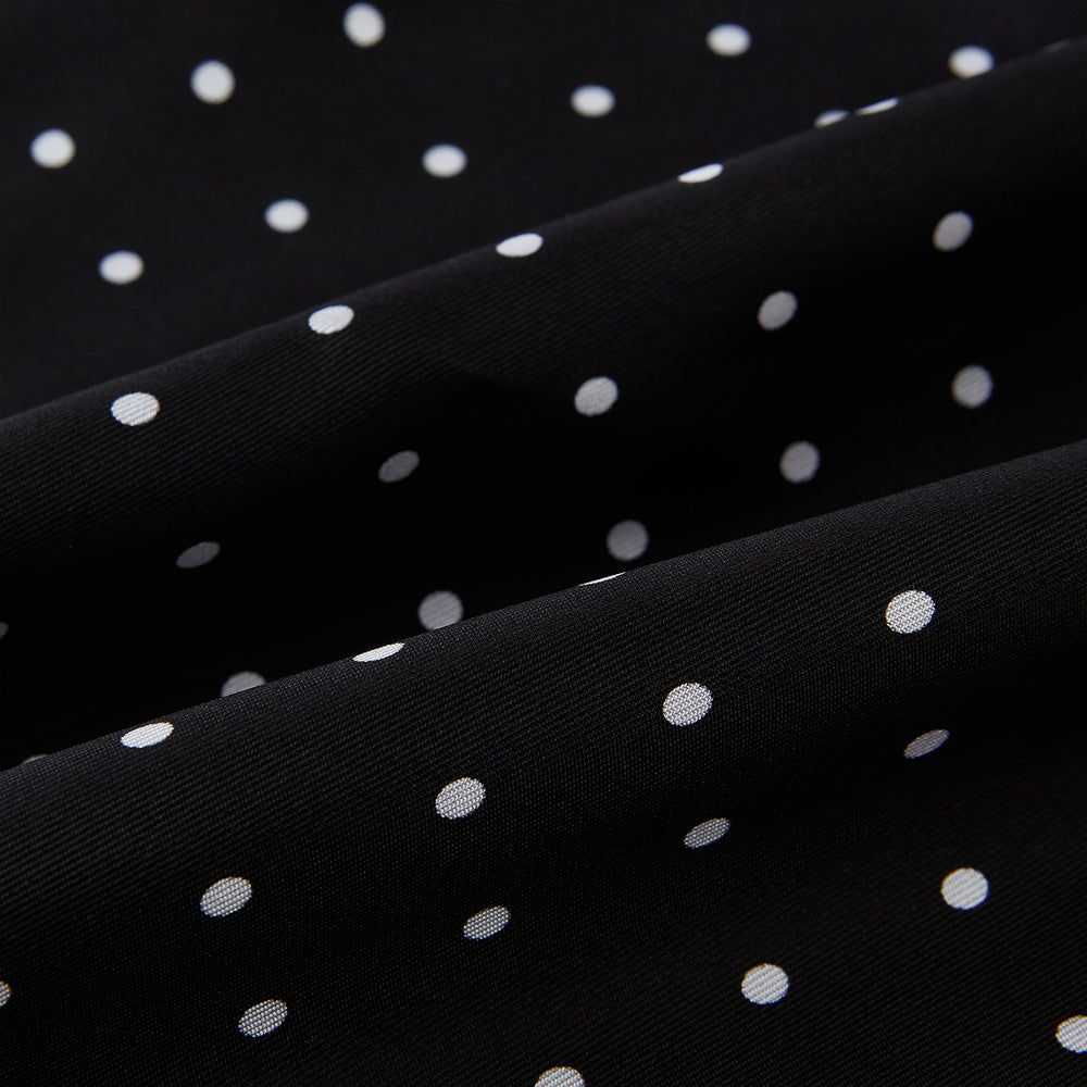 The Black and White Spotted Silk Scarf by Turnbull & Asser features a spotted design, neatly folded at the top and spread out at the bottom, with the brand's name printed in white near its fringed ends.