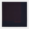 View 3 of product The Turnbull & Asser Navy and Burgundy Stripe Silk Pocket Square features diagonal stripes in one corner, hand-rolled edges, and "TURNBULL & ASSER HAND PRINTED IN ENGLAND" printed in red on luxurious silk.