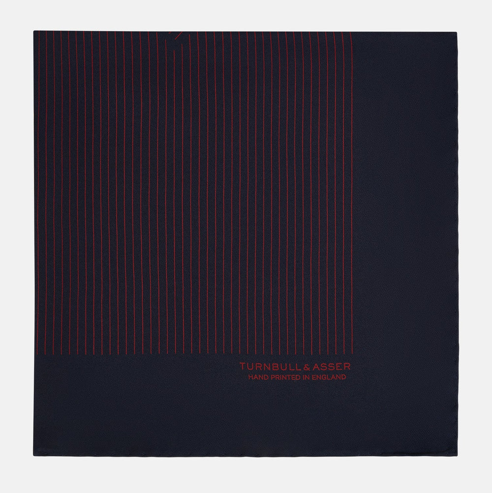 The Turnbull & Asser Navy and Burgundy Stripe Silk Pocket Square features diagonal stripes in one corner, hand-rolled edges, and "TURNBULL & ASSER HAND PRINTED IN ENGLAND" printed in red on luxurious silk.