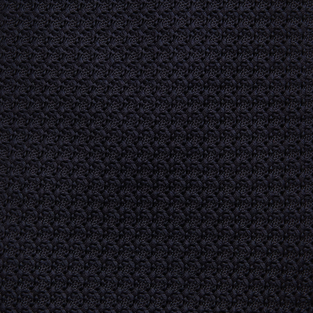 The Turnbull & Asser Midnight Blue Knitted Tie, elegantly textured and displayed on a white background, is a versatile addition to any gentleman's wardrobe.