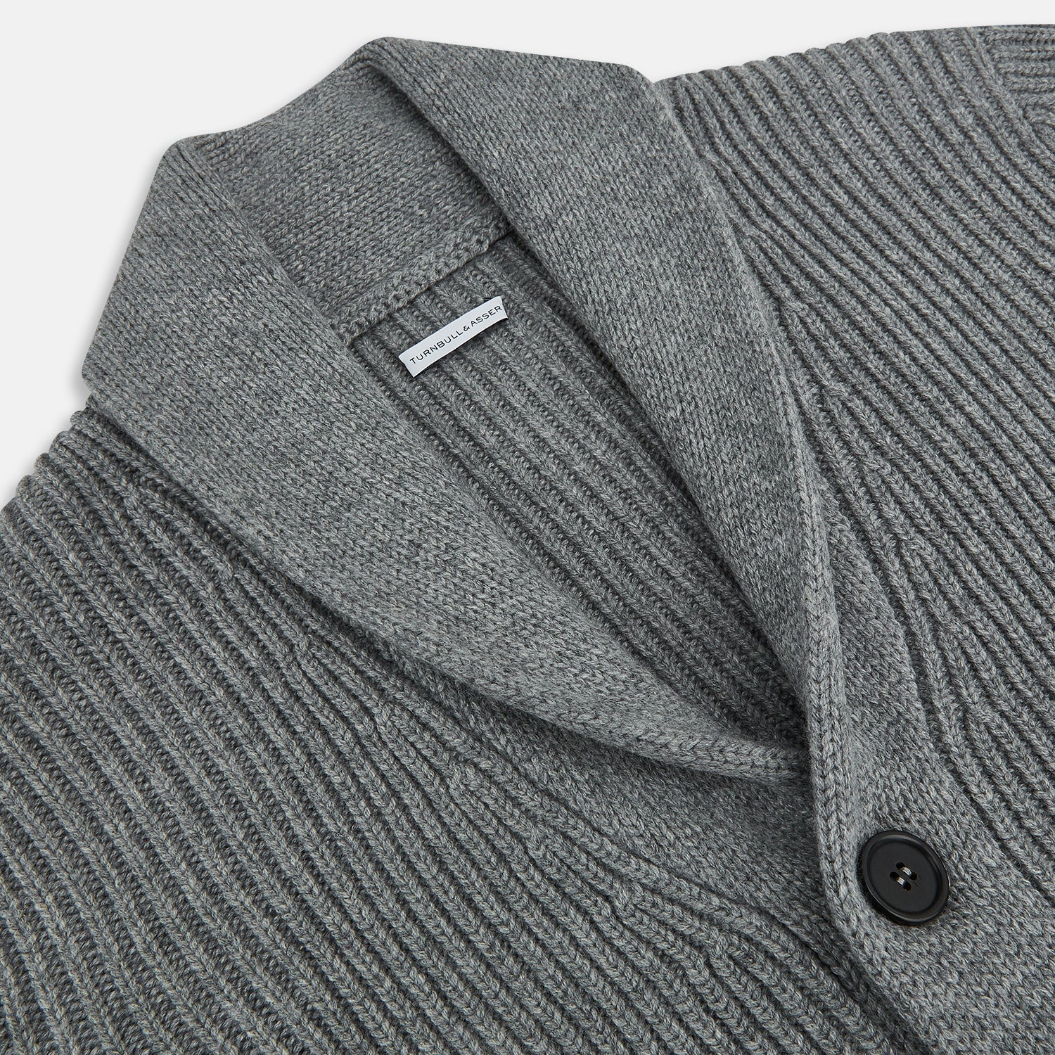 View 2 of product The Turnbull & Asser Grey Melange Cashmere Shawl Collar Cardigan features a ribbed-knit texture, five black front buttons, and two pockets, shown against a plain white background.