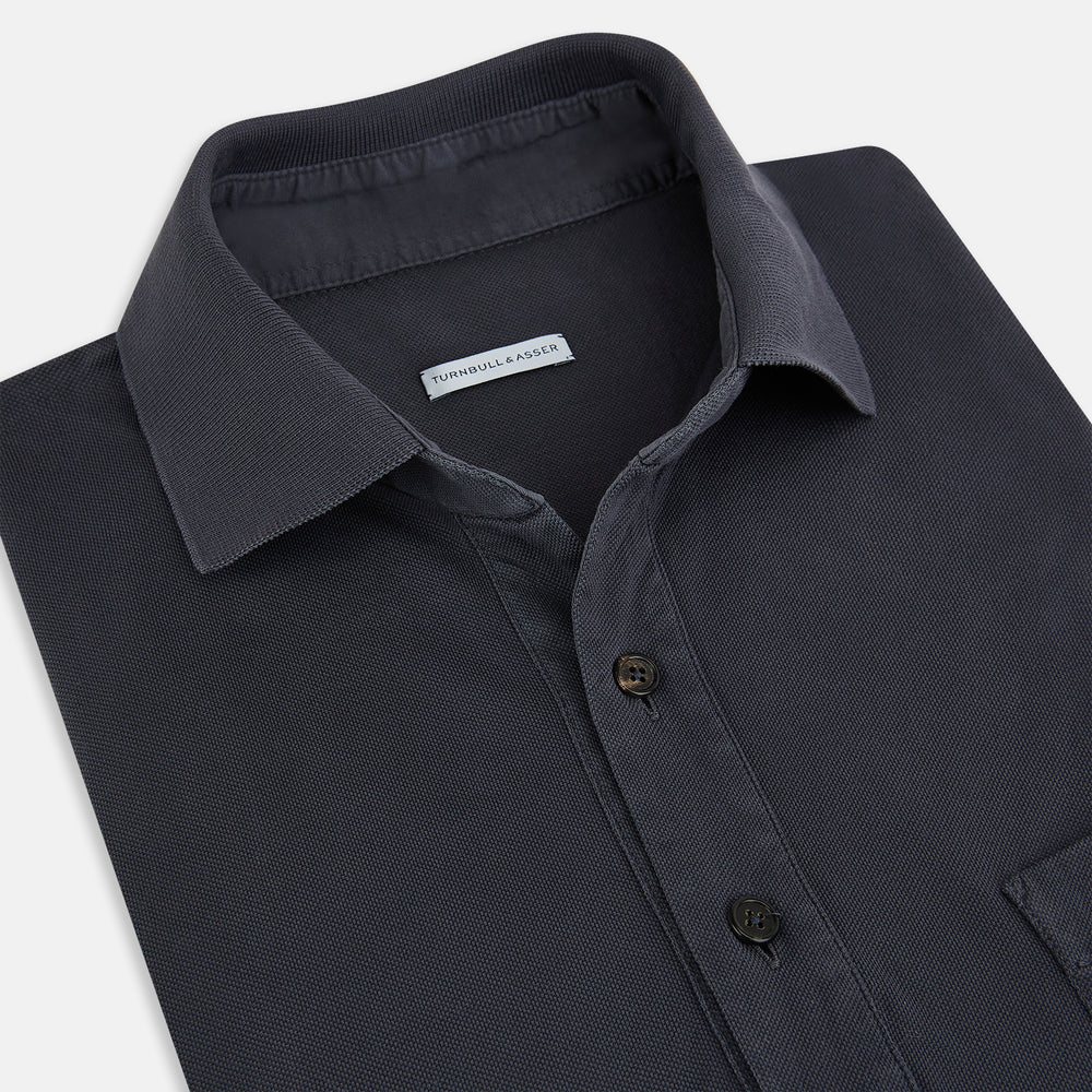The Turnbull & Asser Charcoal Polo Shirt is a short-sleeve, soft cotton jersey top with a collar, three-button placket, and a left chest pocket, shown on a plain white background.