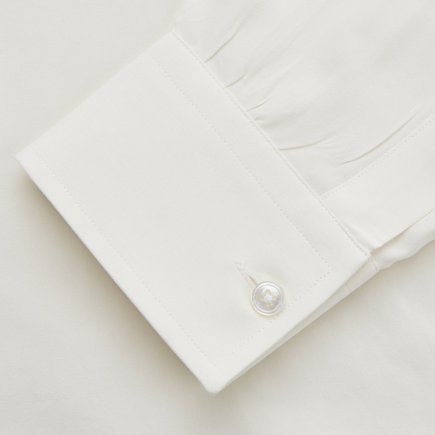 View 3 of product The Cream Silk Long Point Embroidered Eamon Shirt by Turnbull & Asser features long sleeves, a pointed collar, and delicate botanical embroidery. Its buttoned cuffs and tailored fit make it an elegant partywear choice.
