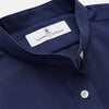 View 2 of product The Turnbull & Asser Blue Soft-touch Silk Lauren Shirt is a navy, long-sleeve button-up with an Igret stand collar, white buttons, curved hem, relaxed fit, and elongated body for a modern look, shown laid flat on a white background.